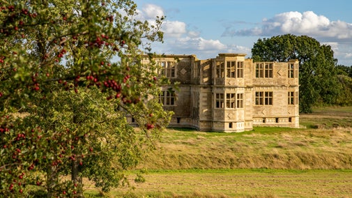 The garden lodge stood in the early autumn sun behind a bush of Hawthorn berries.